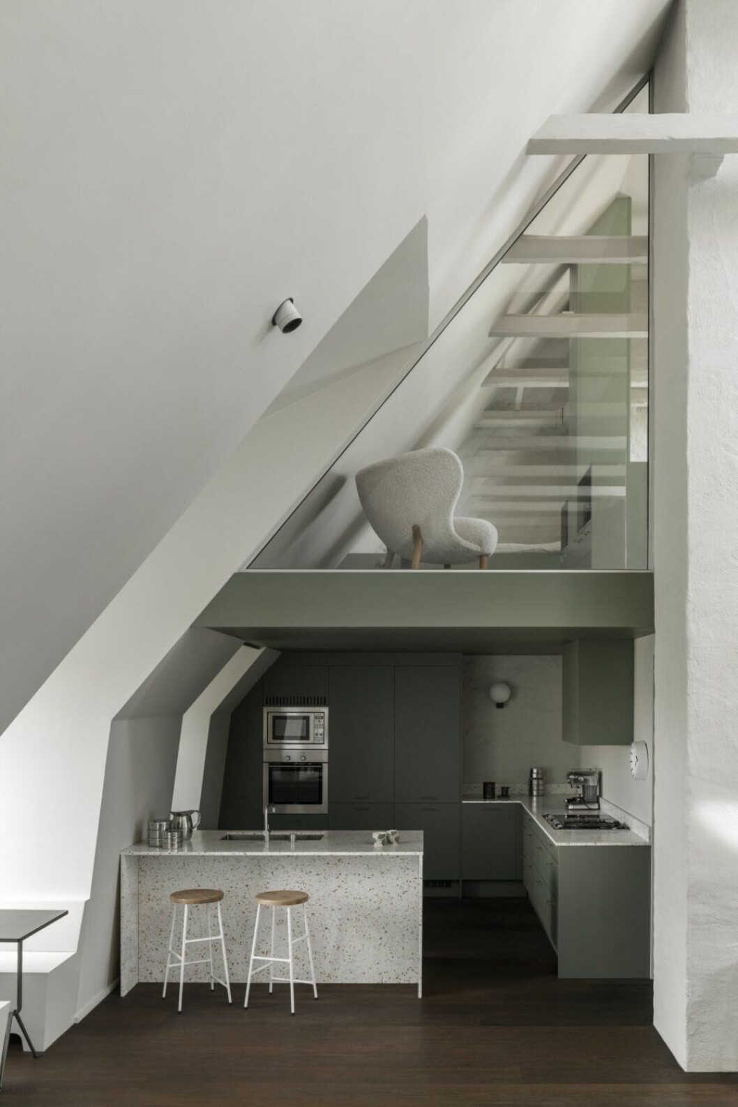Ett loft byggdes in över köksdelen och blev ett barnrum, med glasruta mot stupet. Pallar i köket är Cornet stool, ritad av Jonas Trampdach för Hay.