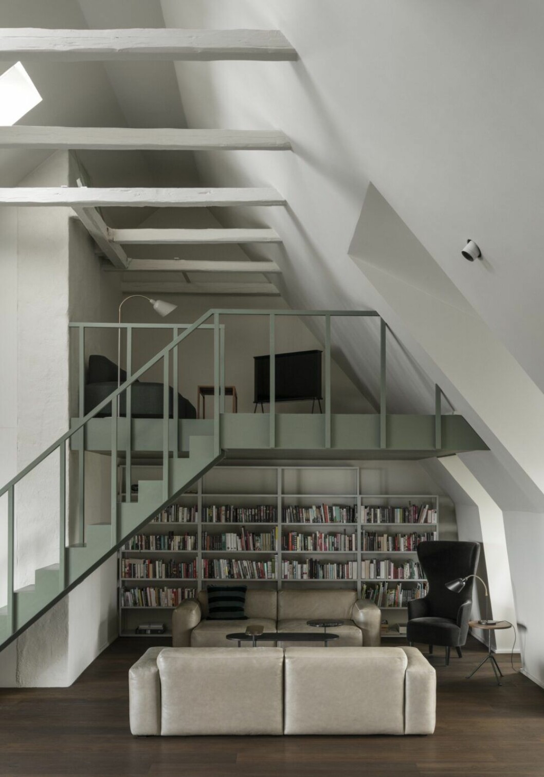 Läsliv under loftet. Bibliotek och läsplatser utan tv. Soffor Mags soft från Hay. Öronlappsfåtöljen är Tom Dixons skulpturala Wingback chair (2014), ett nytag på engelska 1600-talsmöbler.