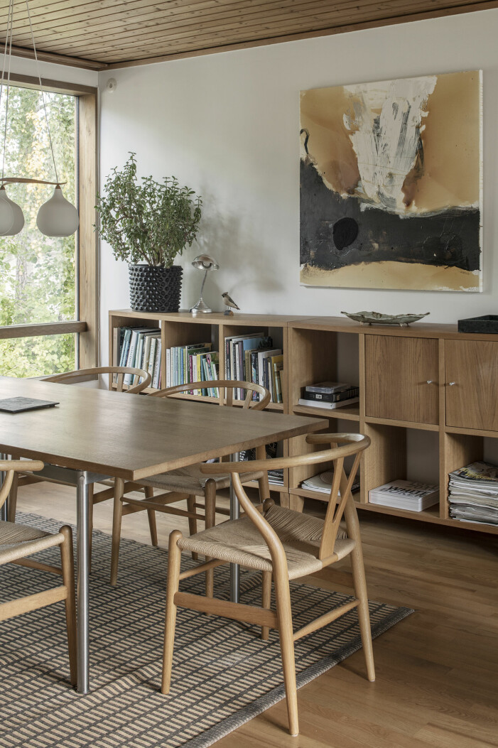 I matsalen står Wegners Y-stolar runt ett av Hans Wegners egna bord. Matta, Woodnote. Lampa, Luxus. Skänken/bokhyllan? har Klara kommit över via Facebook market, där den bortskänktes. Hallery Furuvagen 4 hemmagalleri i Danderyd