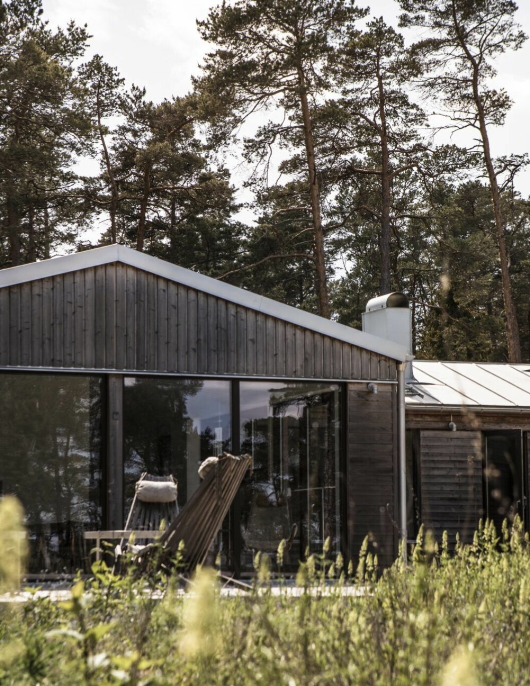 Fasaden har partier med ömsom stående och ömsom liggande lärkträ. Stolarna gjorda av lärkträ och hamparep kommer från EcoFurn.