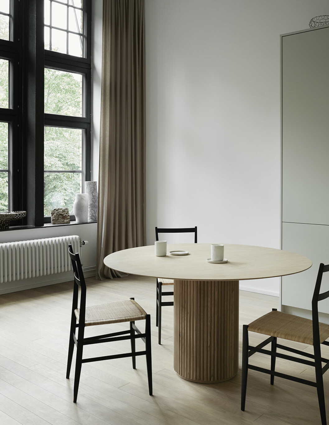 Bord <em>Palais</em>, design Anya Sebton och Eva Lilja Löwenhielm för Asplund. Stolar <em>699 Superleggera – India cane</em>, design Gio Ponti för Cassina. I fönstret står vaser i sten från Jérôme Aumonts <em>Collection particulière</em>. Grovhugget bokstöd, Dusty deco. Sidengardiner Aruba, Astrid textiles. hans matbord