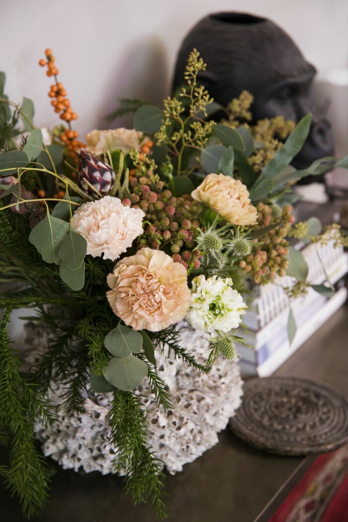En fantastisk julbukett signerad Anna Sellergren med olika sorters nejlikor, ranunkler, leucadendron, eukalyptus och kryptomeria som andas vinter och jul. Vas gjord av havstulpaner från Love Warriors. Julhem floristens gröna jul bukett