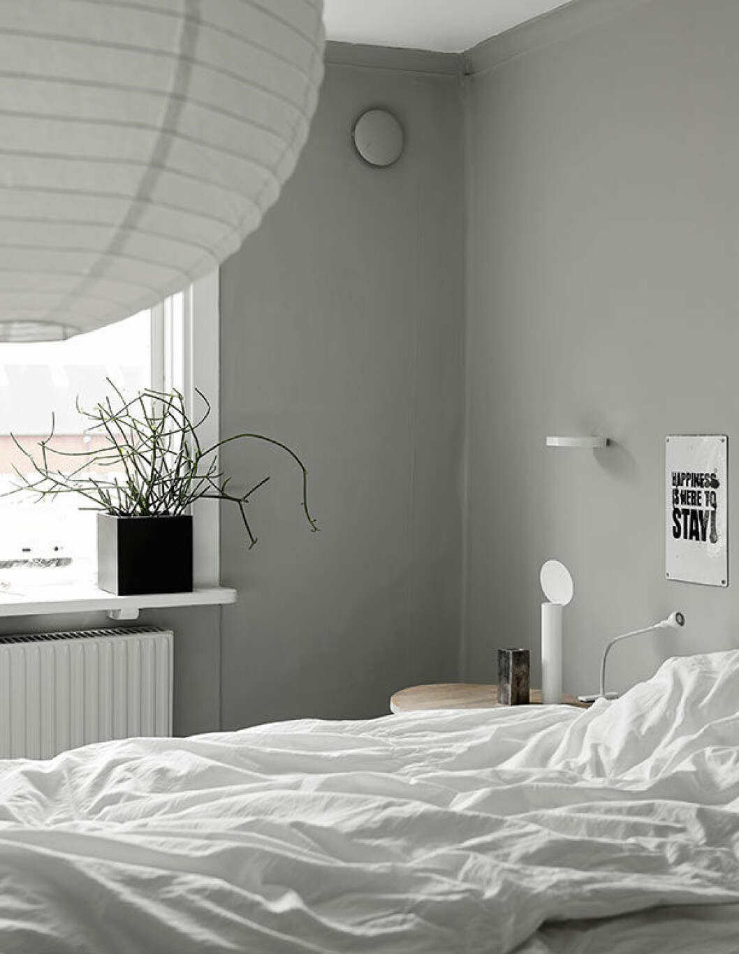 Nygrånad vägg i sovrummet. På väggen, emaljskylt av Therese Sennerholt, lykta Asplund, lampa Ikea och liten rund hylla av Inga Sempé, Lotta Agaton shop. hemma hos Annaleenas hem residence sovrum