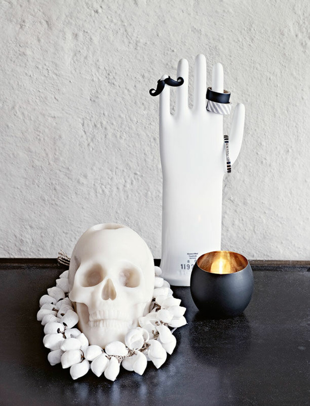 <em>Dödskalleljus och snäckband från lovewarriors.se. Handen i porslin är ett nätfynd.</em> hemma hos hannah lemholt 1