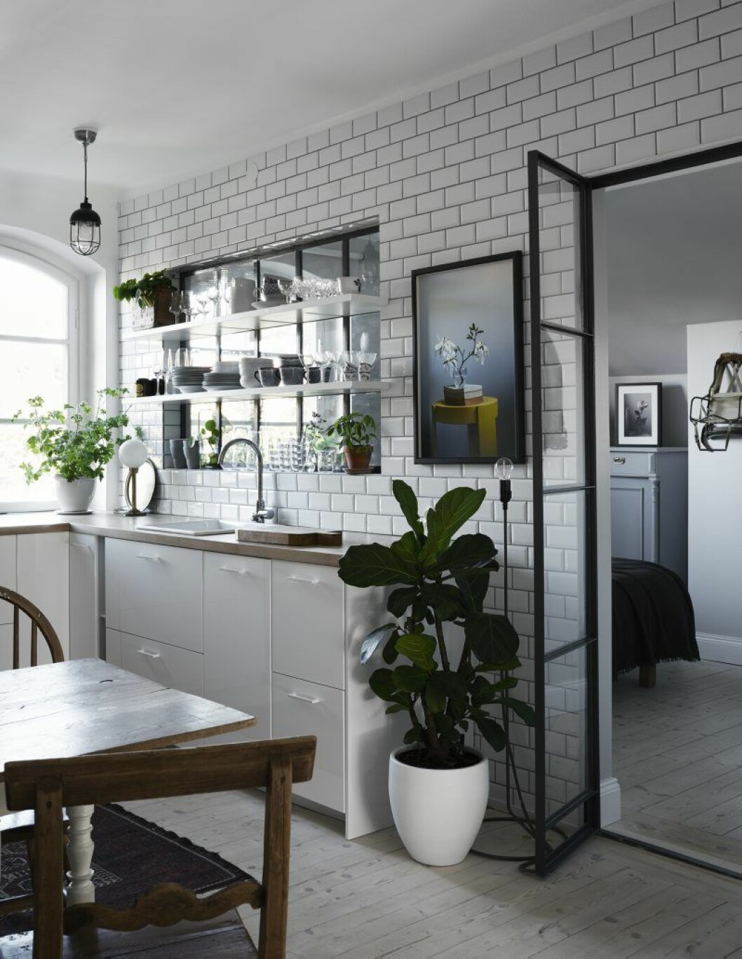 Den smarta lösningen med egendesignat fönster och glasdörr mellan sovrum och kök gör vindsvåningen mycket ljusare. Tavlan ovanför fiolfikusen är en av Louise Ljungbergs egna bilder. Liknande finns att köpa på hennes hemsida loui-loui.com. Hemma hos Louise Ljungberg_3