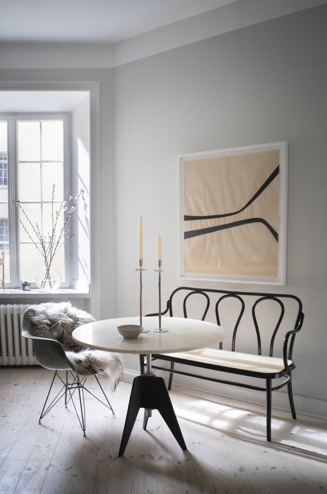 I köket äter familjen frukost runt Tom Dixons Screwtable. Konstverk av Åsa Stenerhag, ljusstakar, Svenskt tenn, och karmstol av paret Eames.