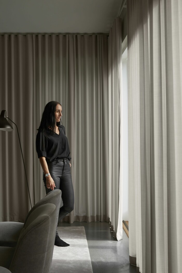Mathilda framför fönstren mot uteplatsen. Omklädda fåtöljer från Ikea. Golvlampa Mantis, design Bernard Schottlander. Hemma hos MK Design Studios grundare Mathilda Karlsson