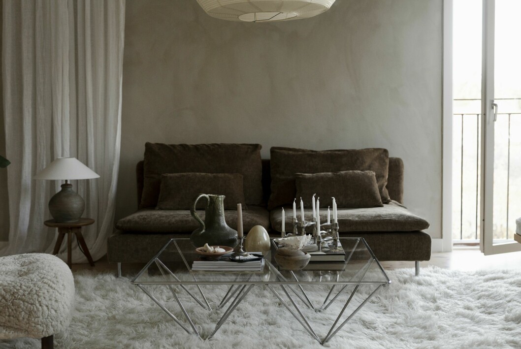 Soffa Söderhamn, Ikea, med överdrag från Bemz. Flokatimatta, mattoronline.se. Soffbordet kommer ursprungligen från Italien, köpt second hand. Bordslampa i keramik, Watt & veke. Pall, second hand. Ljusstake, Nagel. Linnegardinerna, Ohlssons tyger. Väggar målade i mineralfärg från Jotun, kulören Soothing beige. Hemma hos stylisten Caroline Borg
