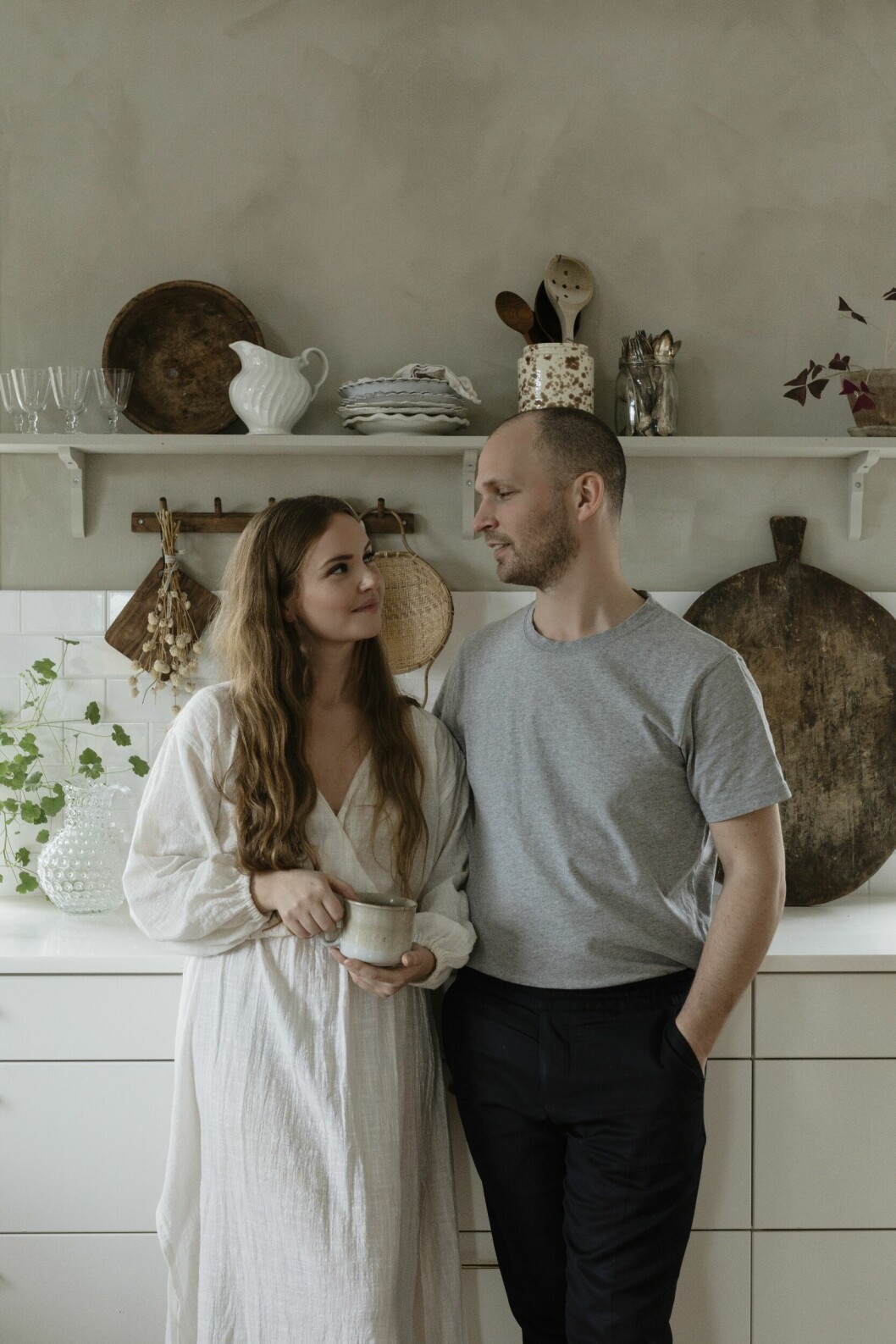Caroline och Jens i köket. Knopplist i betsad rökt ek, Norrgavel. Äldre skärbräda, Petite Bouvin. Durkslag i bambu, Mimou. Blommor och kruka från Årsta blomsterhandel. Hemma hos stylisten Caroline Borg