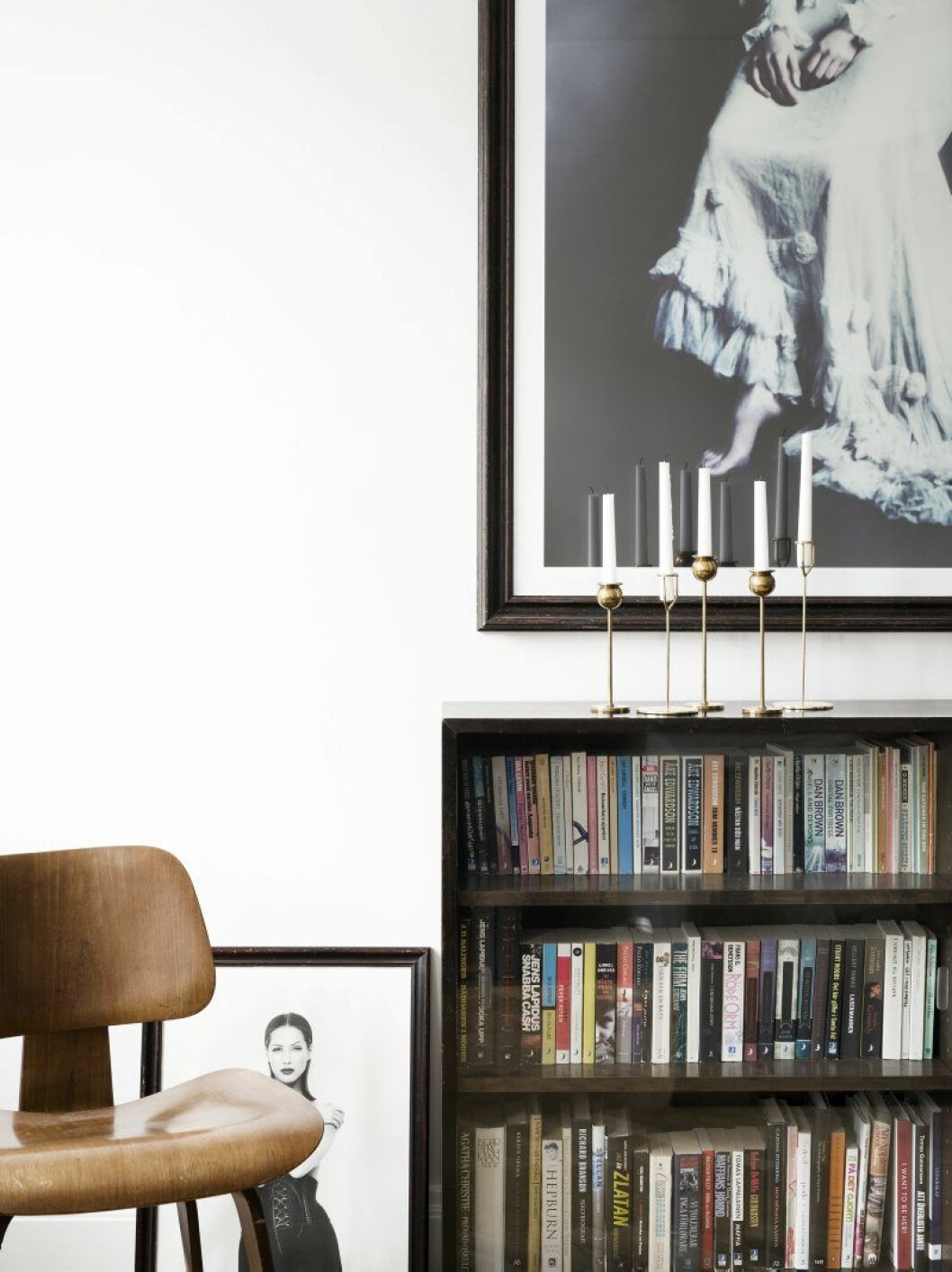 Fotokonst ovanför bokhyllan, Julia Hetta. Mässingsljusstakar Svenskt tenn och H&M Home. Stol, Eames, bakom står ett loppisfynd, en tidig bild på supermodellen Christy Turlington.