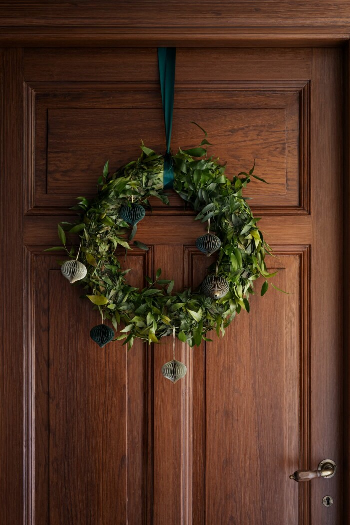 Dekorera kransen med det du har hemma! Det kan vara allt från kottar till julgransdekorationer. Foto: H&M Home grön julkrans med julgransdekorationer i