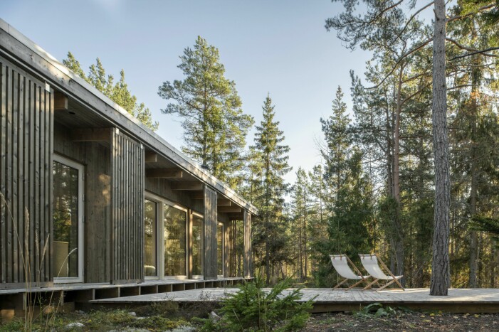 Huset är placerat på en höjd några minuters promenad från vattnet. I däcket som skjuter ut som en udde på ena sidan har Emelie sparat en stor tall. Hus placerat på en höjd.