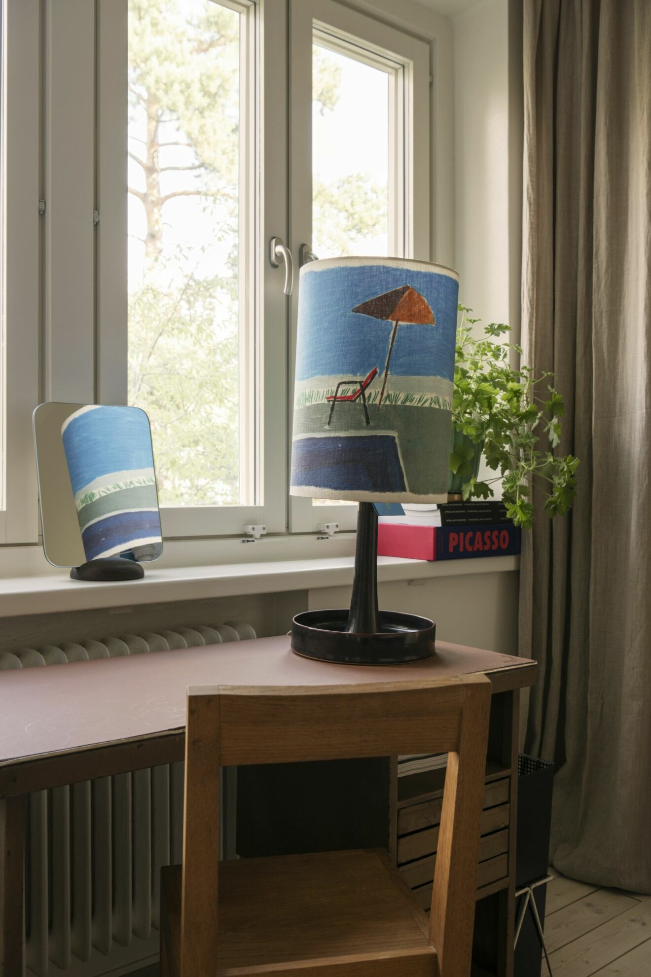Italienskt skrivbord i industristil av Giò Ponti. Lampfot i ­keramik av Stig Lindberg med skärm från Acne studios med motiv av Larry Stanton.