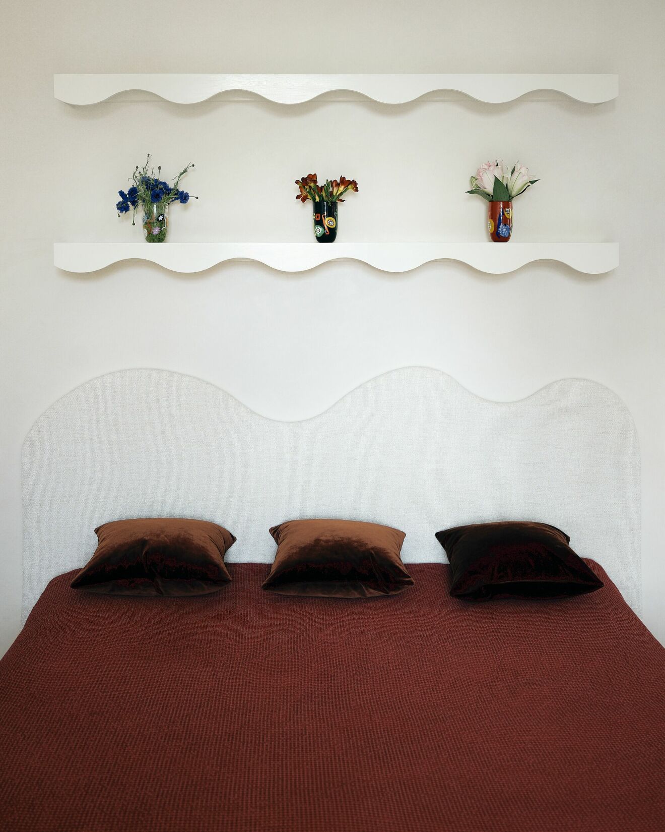 sängen i sovrummet. Väggarna är i stucco lustro och sänggavel och hyllor ovan är specialritade för projektet.