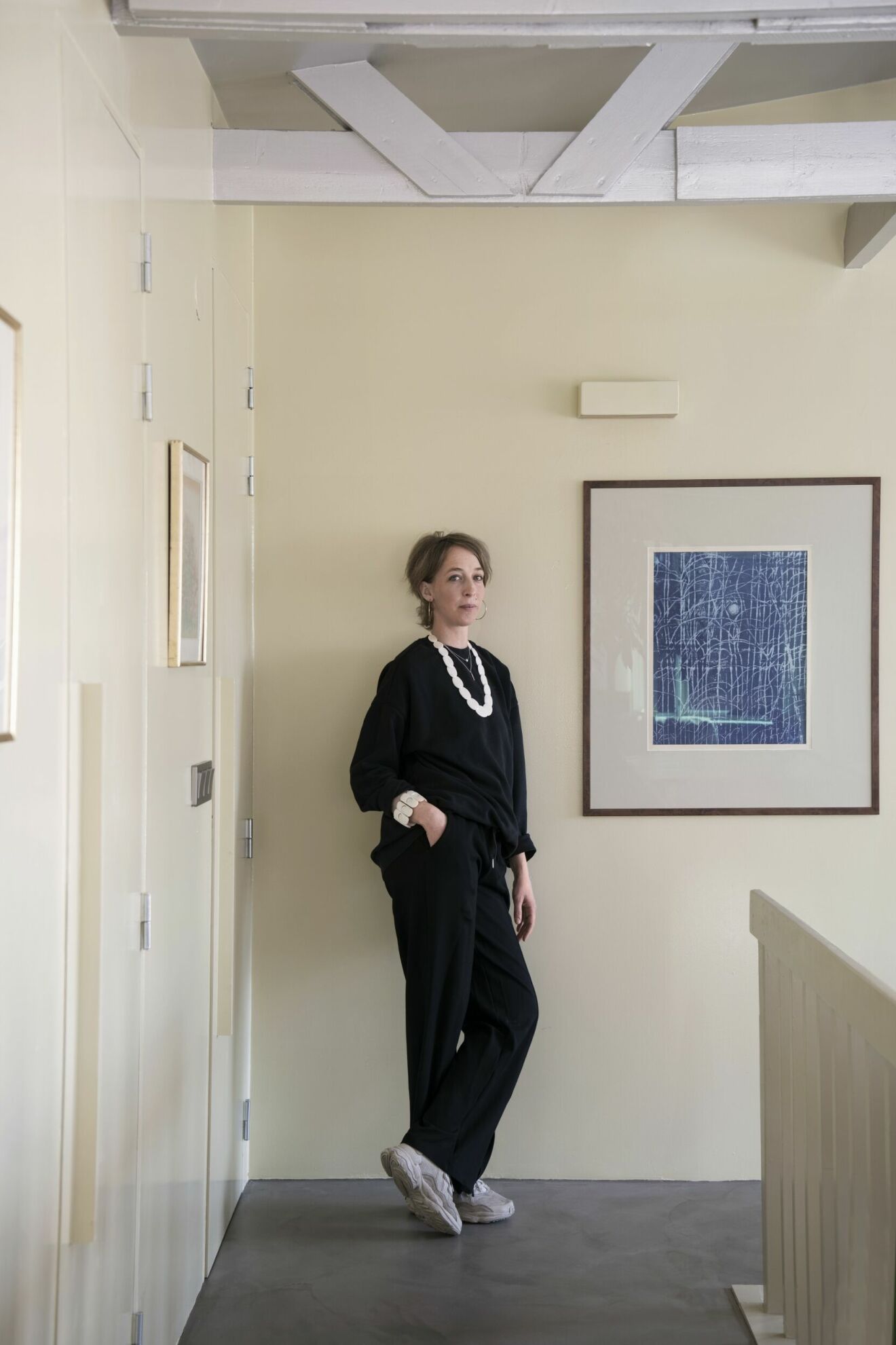 50-talsvilla ljusgula väggar konst kvinna klädd i svart inredare