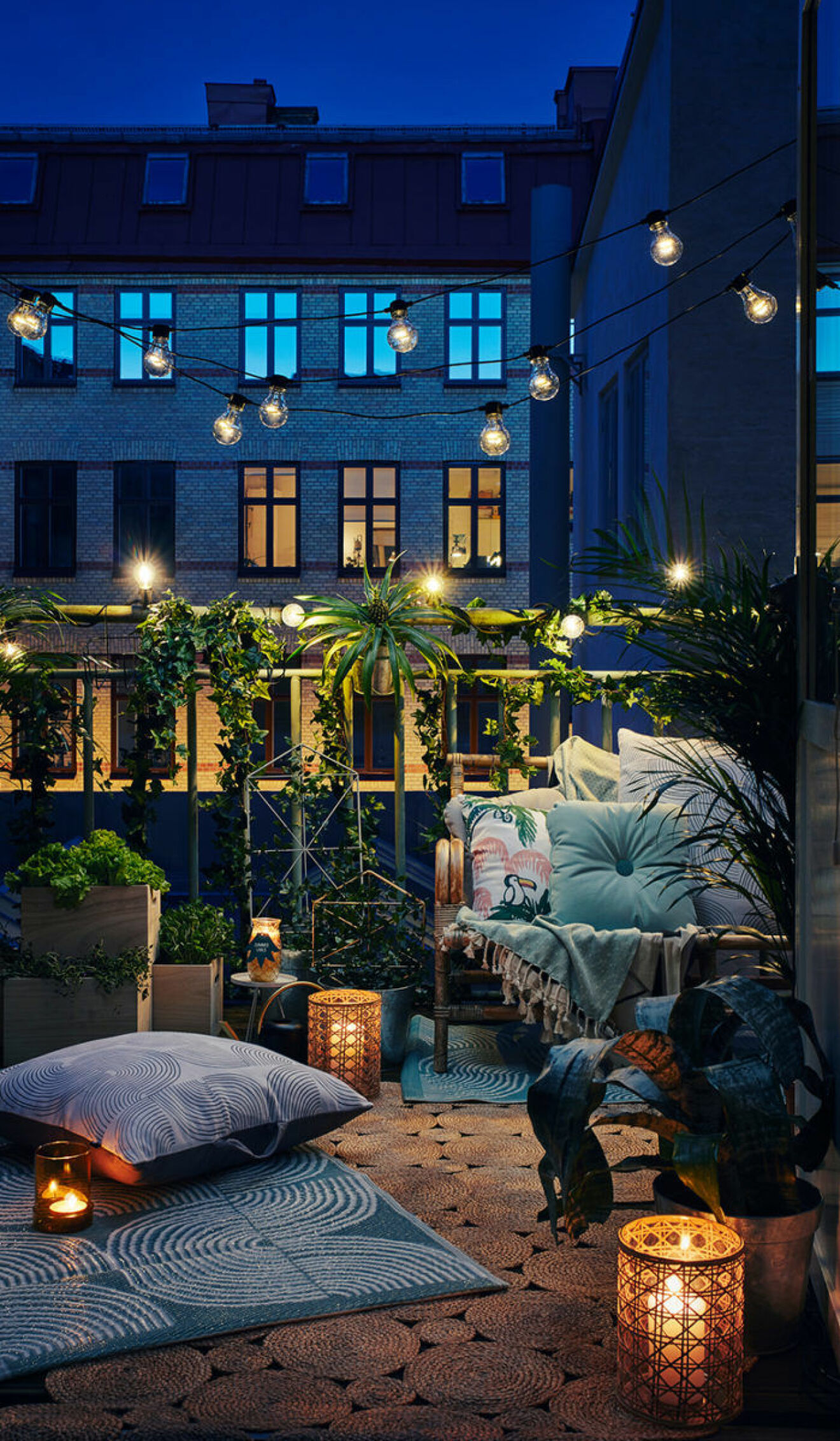 Scandinavian balcony by night, lit with stringlights and candles.