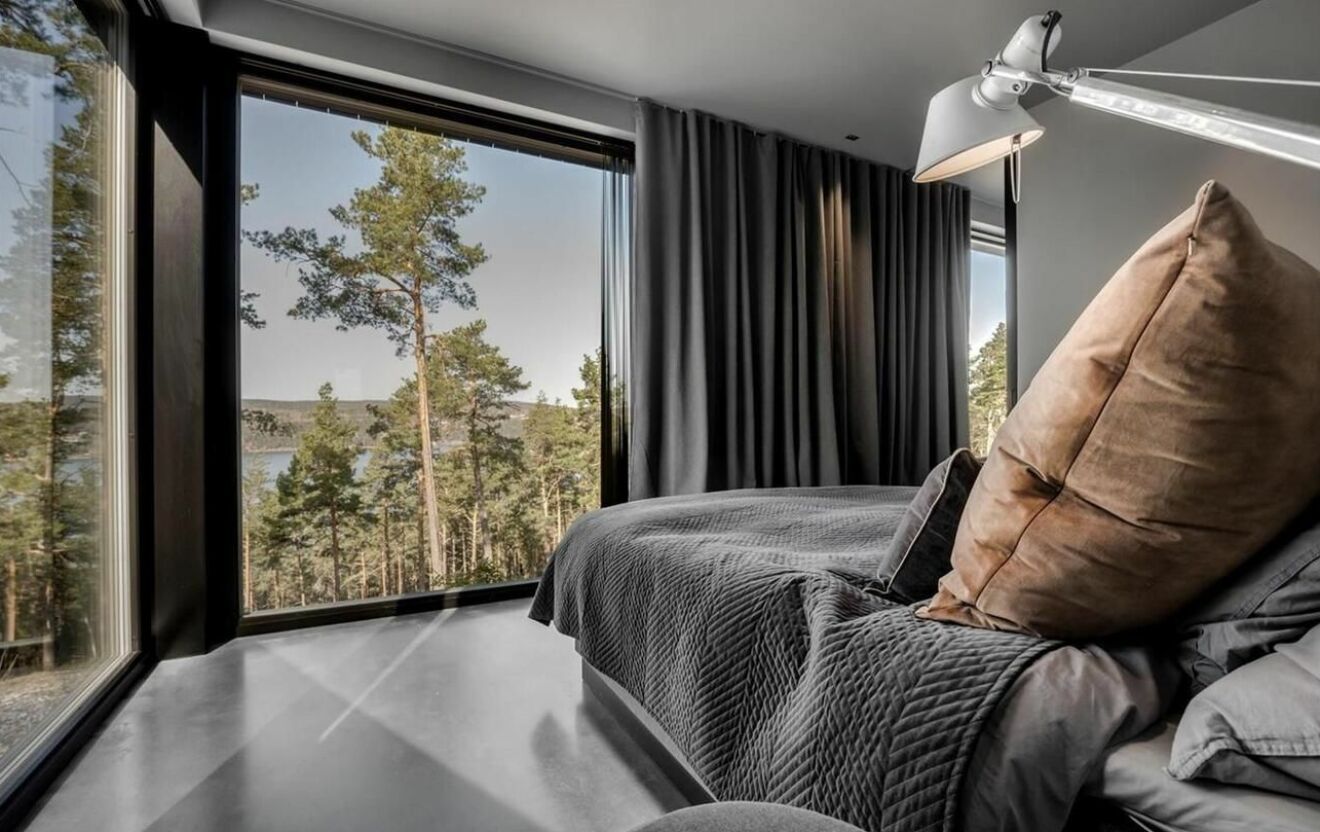 ett sovrum med utsikt över skog