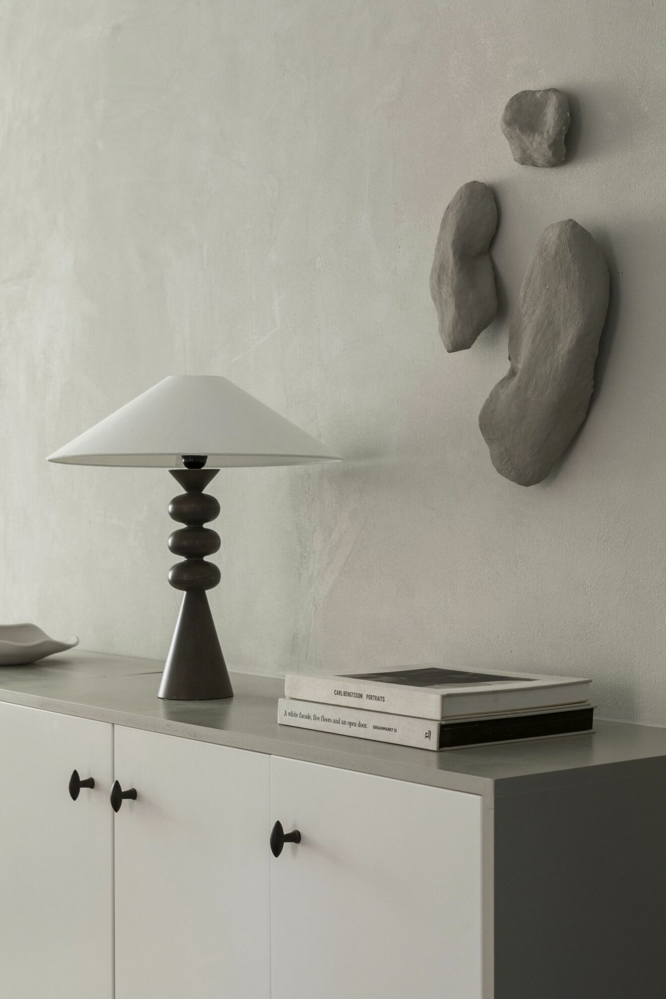 Lampa från Zara home med skärm från Watt &amp; veke, väggskulpturer av Lovisa Häger.