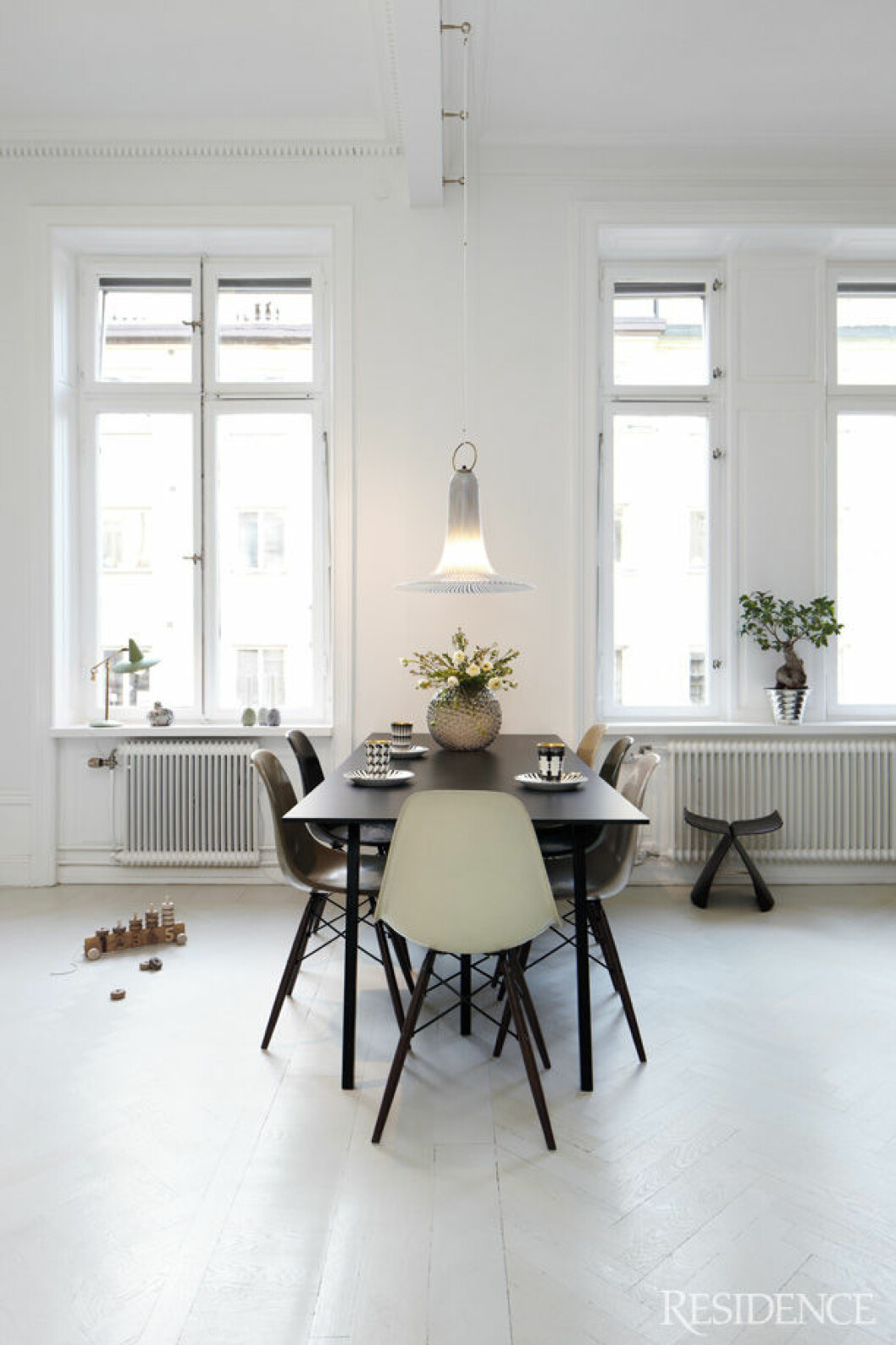 Den lilla mintgröna lampan i fönstret är en av Joannas absoluta favoritsaker i hemmet. Hängande glaslampa från Murano. Bord Loop Stand från Hay, Eames-stolar och pallen Butterfly av Sori Yanagi. Koppar av Åsa Lindström på Sailor-fat från Gustavsberg. Vas och kruka, Svenskt Tenn.
