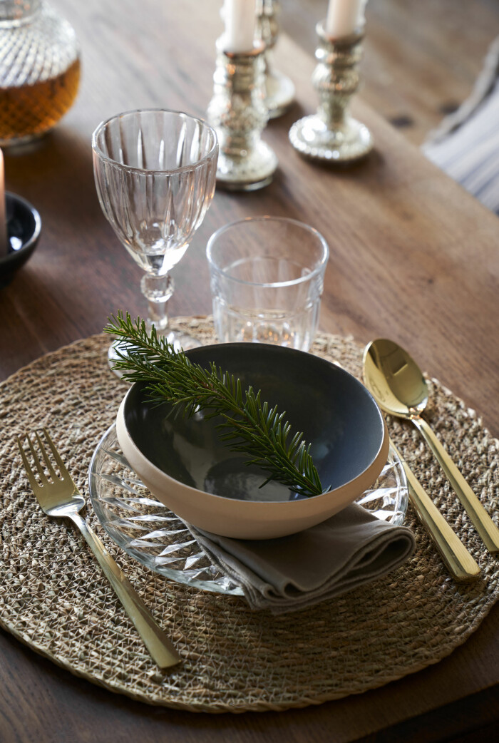 Några enkla detaljer kan vara det som ger juldukningen ett festligt lyft. Foto: Sostrene Grene juldukning med guldbestick och gran