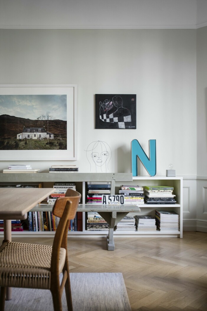 I matsalen står en gammal kyrkbänk från Dalarna som inte fick plats på Jespers och Lottas lantställe. Den fick bli kvar här. Foto, Alexander Crispin, svartvit tavla av Daniel Milton och huvudet i ståltråd är ett porträtt av Lotta av Klas Fahlén. Matsalsinredning konst