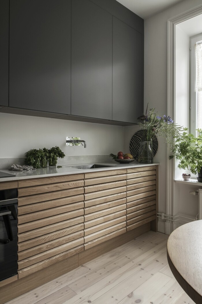 Bänkskåpen är i massiv ek från HTH:s serie <span class=" italic" data-lab-italic_desktop="italic">Nordic Spirit</span>, medan väggskåpen har släta luckor i Fenixlaminat i färgen <span class=" italic" data-lab-italic_desktop="italic">Mörk sand.</span> Kök från HTH i ek och fenixlaminat