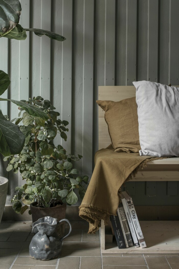 En fotostudio på Holländargatan 33 i Stockholm blev drejarverkstad. Mörk kruka med en träsoffa och växter.