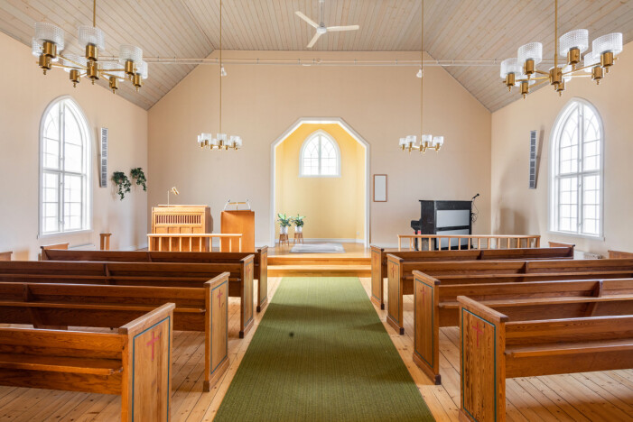 I den spektakulära kyrksalen finns samtliga bänkar och armaturer bevarade. Kyrksalen med bänkar i trä