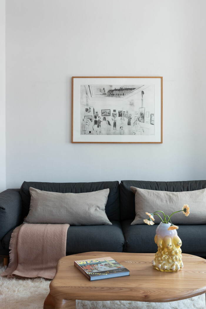 Soffbord i design av Niklas Runesson med vas av Hanna Hansdotter Tavla på vägg ovanför soffa och vas av Hanna Hansdotter på soffbordet