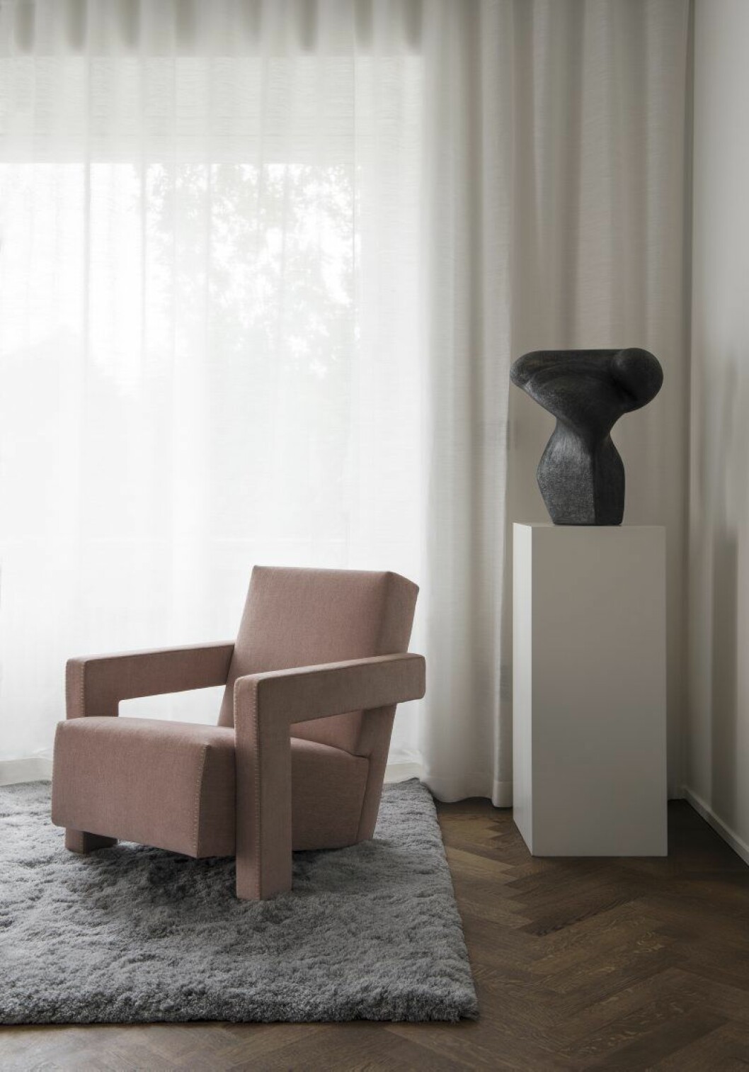 Handtuftad ullmatta från JoV och fåtöljer Utrecht från Cassina. I vardagsrummet står ett av Jennies käraste konstverk, en skulptur på piedestal av koreografen och dansaren Bo Arenander, som tvingades sluta dansa.