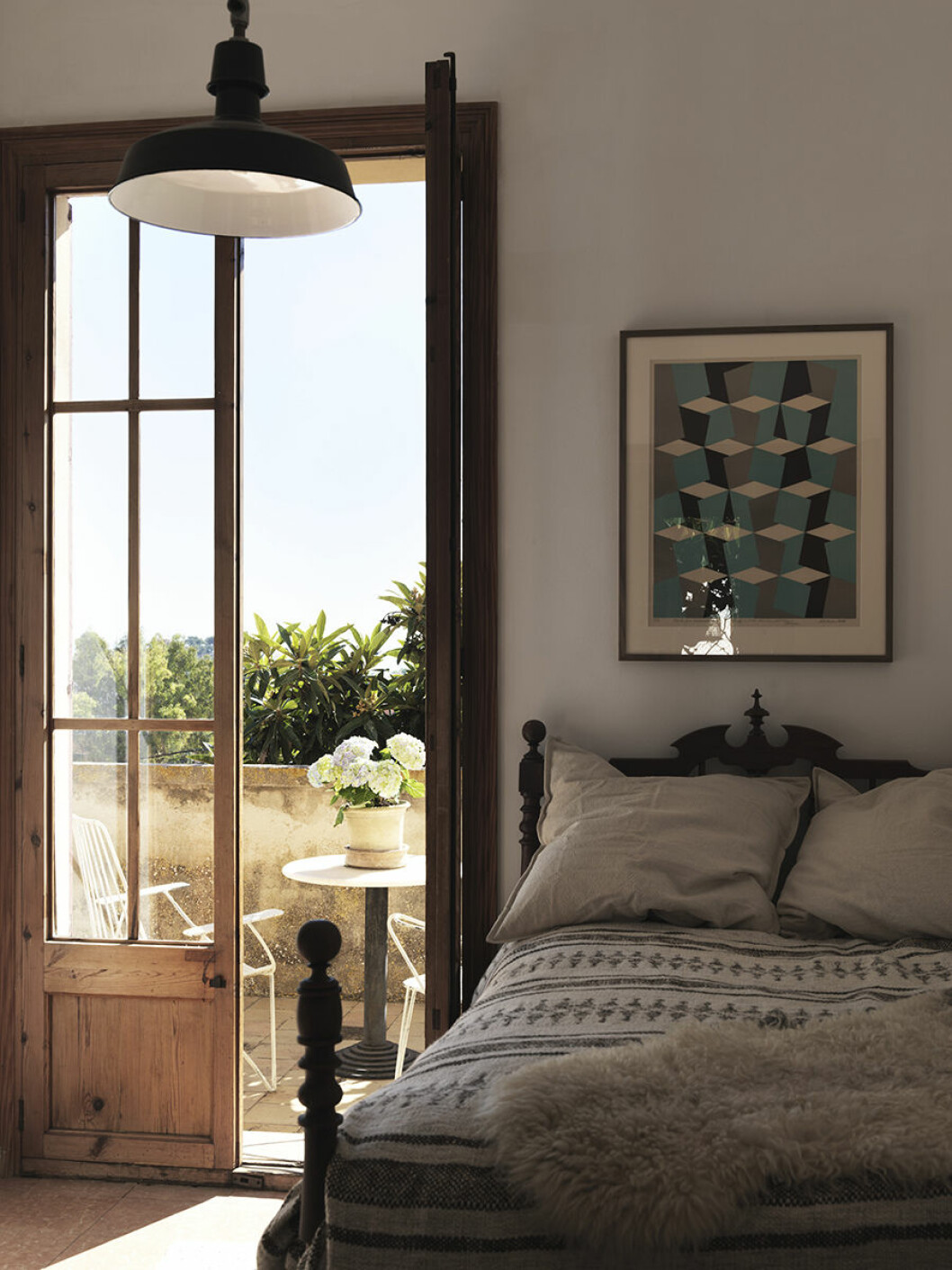 Gästrum med utgång till terrassen. Sängen tillhör huset, litografiskt tryck av Wilhelm Wik som Lina fått av sin bror. Överkast och kuddar Zara Home. dusty deco mallorca gästrum