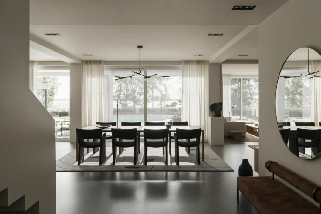 Matsalen med utsikt mot sjön. Matbord 195 naan, Cassina. Stolar Crown chair, Massproductions. Taklampa BD.09.01, Lindsey Adelman. Matta, Liljencrantz design, specialtillverkad av Kasthall.