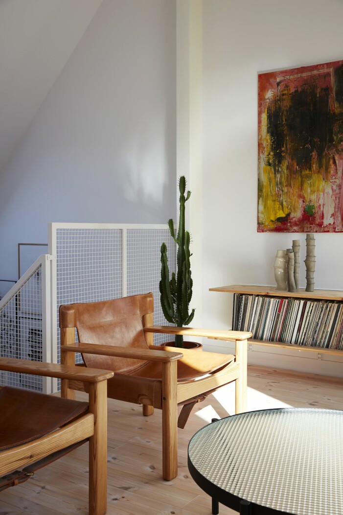 På översta nivån samlas familjen på kvällarna för gemensamt häng. Tavlan är av Mathias bror Andreas Steffen, vaserna är från Bang Bang Studio, och vintage-fåtöljerna är av Karin Mobring för Ikea. Soffbordet Tab är från Bolia. Fasaden i ljusgrå betong smälter in i det lågmälda 50-talsområdet. I fönstret mot nordväst skymtar tonårssonen Bastians rum. Många olika våningar i Stadsradhuset i Aspudden.