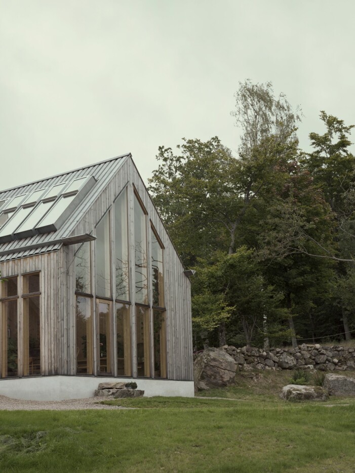 På Rörbäck forest retreat smälter arkitektur, design och natur sömlöst samman. Hus med stora fönster.