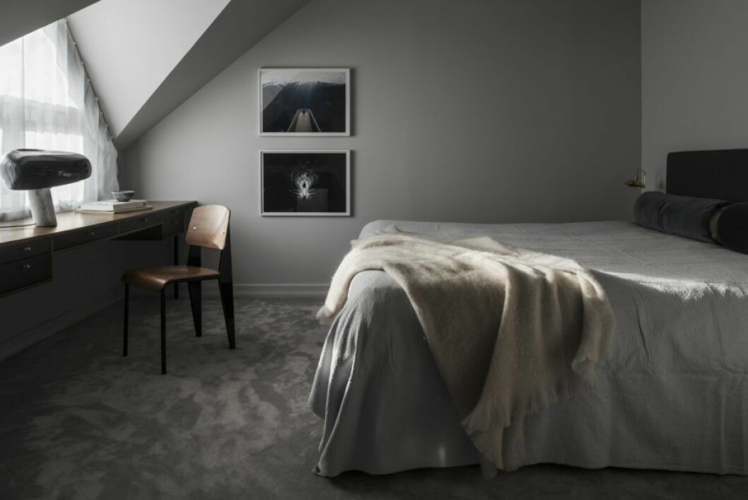 Ett sovrum där grått dominerar färgkartan. 