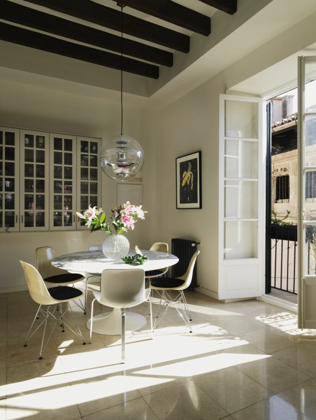 Vid balkongen i köket står Eero Saarinens bord Tulip omgivet av stolarna Eames DSR och PK-8, av Poul Kjærholm för Fritz Hansen. På bordet, vas Dagg, Svenskt tenn, lampa Globe, design Verner Panton.