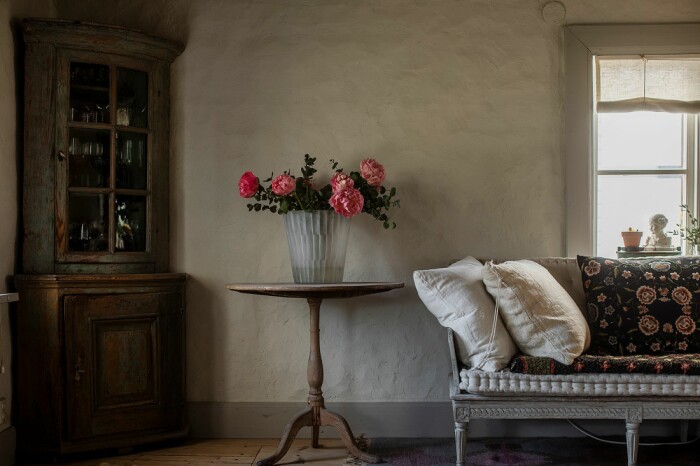 Vackert blomsterstilleben på pelarbordet. I flera av rummen finns lerklinade väggar. Åsa Larsson säljer sitt hus i Mariefred lerklinade väggar 1700-tal
