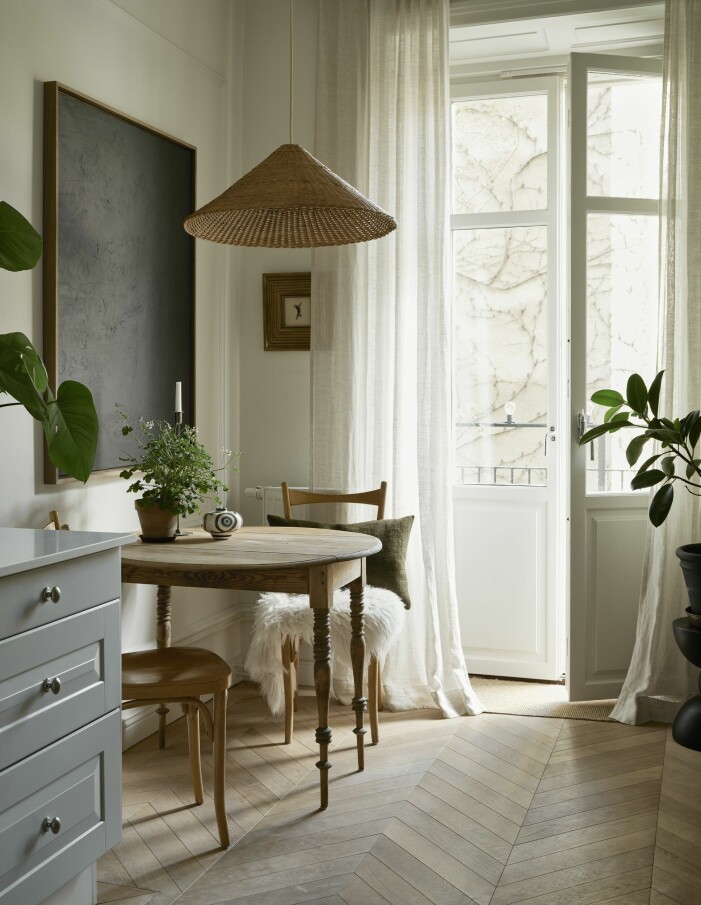 Ovanför matbordet hänger ett verk av Mattias och på väggen bakom ett av Carolina. Taklampa, Ferm living, och gardiner, Gotain. Bordet och stolarna är second hand-fynd. Matplats med stor tavla.