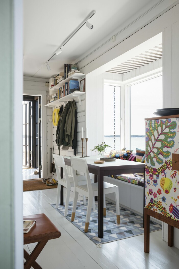 Vid bordet står två av Thomas TS-stolar. Skåp av Josef Frank, klätt med tyget Brazil, Svenskt tenn. Matplats med mycket färg.