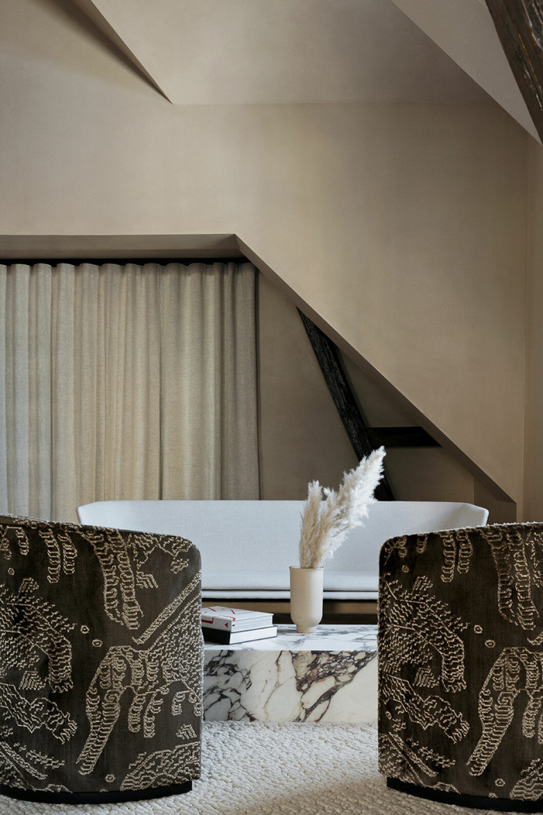 En av sviterna ligger i hörnet av huset och är mysigt inredd som en liten studiolägenhet. Kittväggarna har en mjuk beigerosa ton. designhotell the audo fåtöljer
