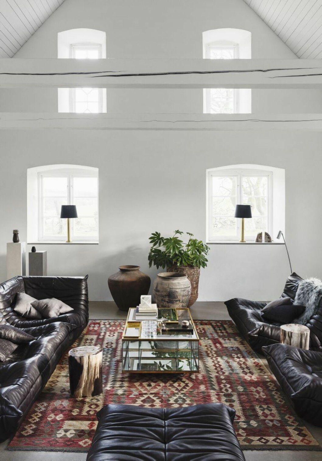 När paret flyttade in fick de gamla möblerna göra plats för nya, lite större pjäser som de klassiska skinnsofforna Togo från Ligne Roset och de auktionsfyndade urnorna. Läslampan Puck av Åke Hultgren. Kuddarna har Magnus syster gjort.