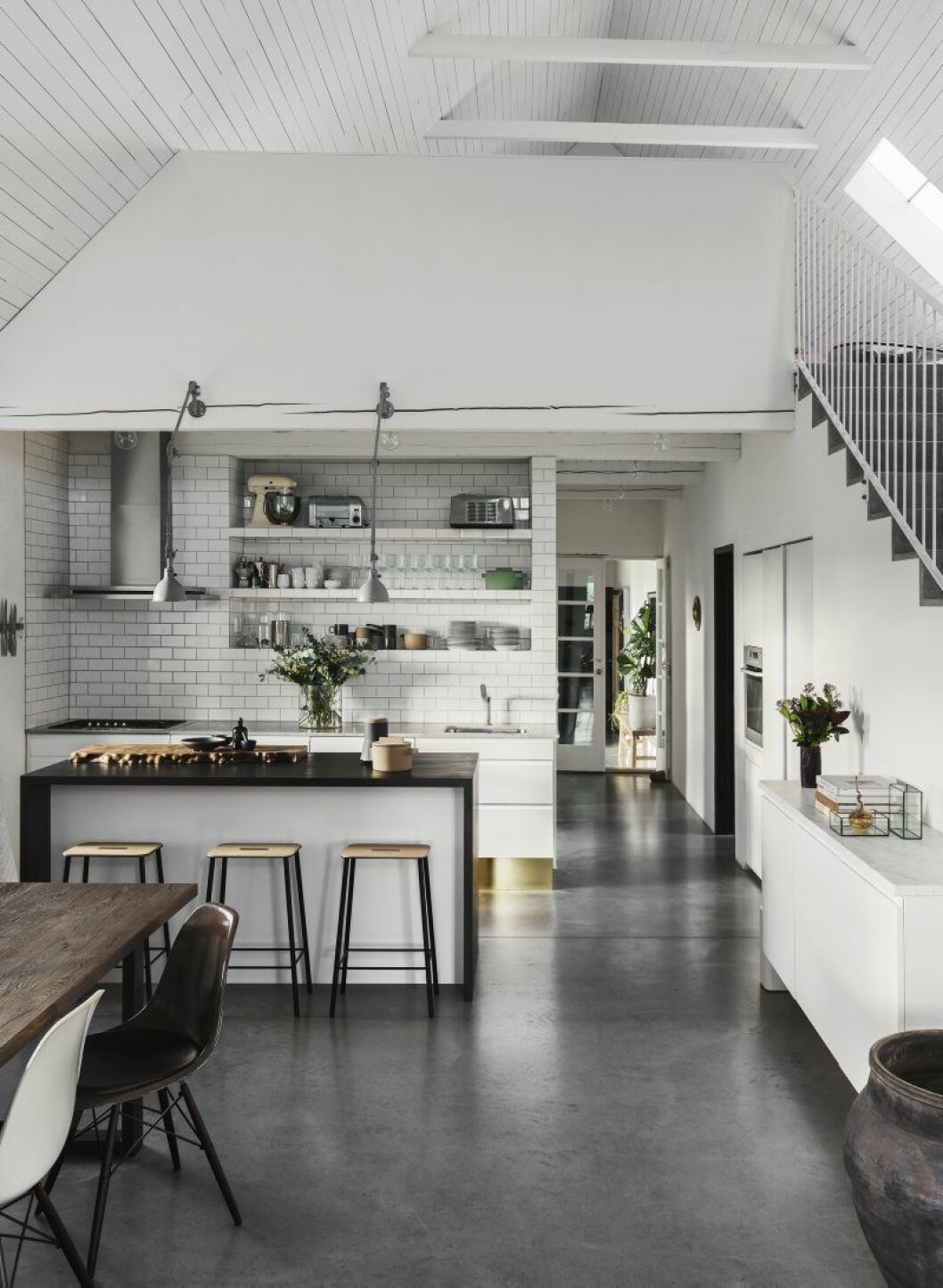 Större delen av huset upptas av ett stort sällskapsrum och kök. Micha och Magnus fick bygga till köksön och sidoskåpet för att få mer plats. Luckorna Solitär är en utgången kollektion från Ikea, de nya bitarna hittades på Blocket. Pallar, Frama och industrilampor, Pefege. Handgjord skärbräda, Sløjd.