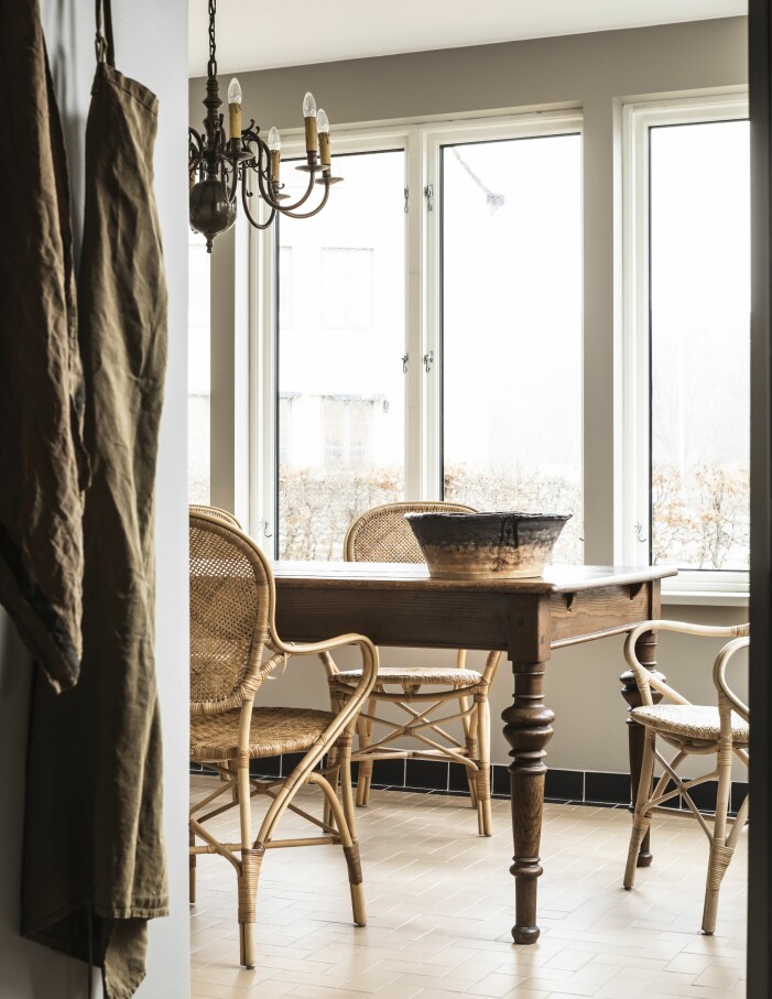 En trädgårdsaltan med klinkergolv blev en nybyggd matsalsveranda och husets bästa allrum. Det tre meter långa matbordet och malmkronan är köpta på auktion. Rottingmöbler Rossini från danska Sika design, som utgår från äldre möbelritningar. Skål i två olika leror av Monica Kylén. Hemma hos grundarna av L:a bruket