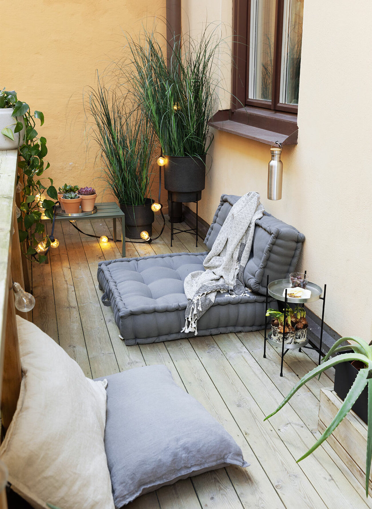 Mysig balkong med låga möbler och möbler på golvet