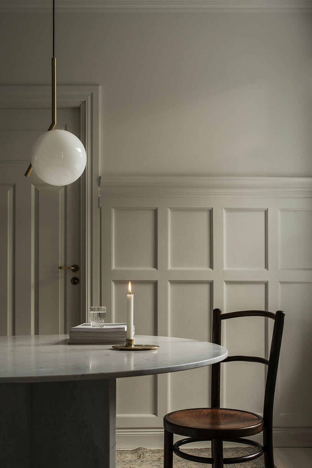 När mörkret faller skapar familjen stämning genom att tända levande ljus. Den moderna formen i Ilse Crawfords vackra ljusstake för Georg Jensen blir en fin kontrast till de gamla väggpanelerna. Nadja matbord
