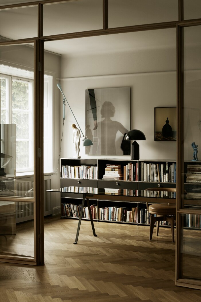 Bokhyllor USM Haller. Vintageskrivbord Frate av Enzo Mari. Skrivbordsstol, vintage Charlotte Perriand. Blå lampa 265, Flos. Svart lampa Atollo, Oluce. Bokhyllor i arbetsrum.