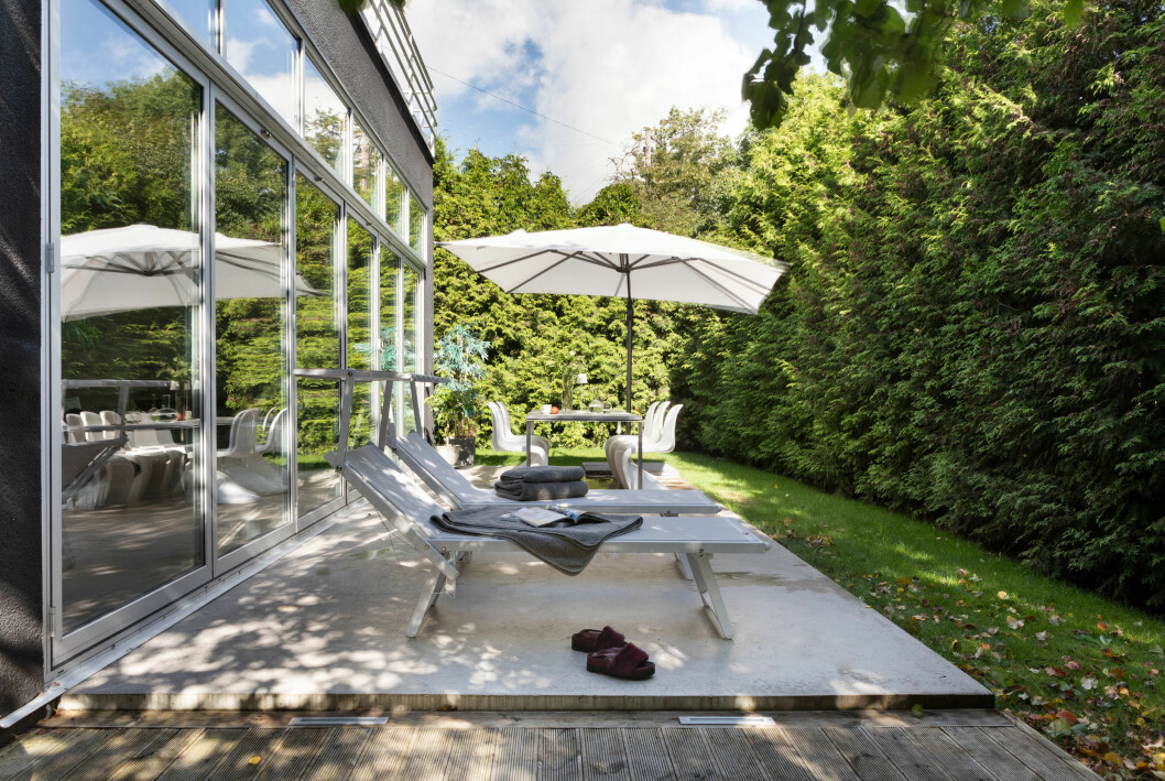 På baksidan av huset breder en gjuten uteplats ut sig i trädgården. Hemma hos Nude of Scandinavia-grundarna: 30-talsvilla med spa.