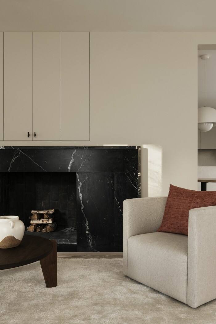 När familjen flyttade in i huset fanns här en enorm öppen spis. Daniel Östman ritade om den, och skapade ett elegant uttryck med spis i svart nero marquina-marmor. Bord, Jean Prouvé. vardagsrum med öppen spis