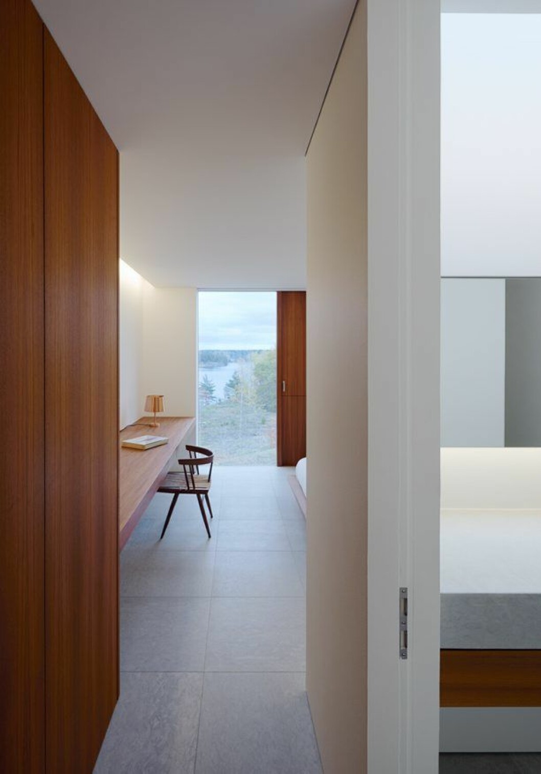 Materialfloran är reducerad, med golv i kalksten och fast möblemang, dörrar och fönsterkarmar i teak. Förutom stolar av George Nakashima märks en lampa i mässing av Jonas Lindvall. Villa Palmgren, John Pawson Limited
