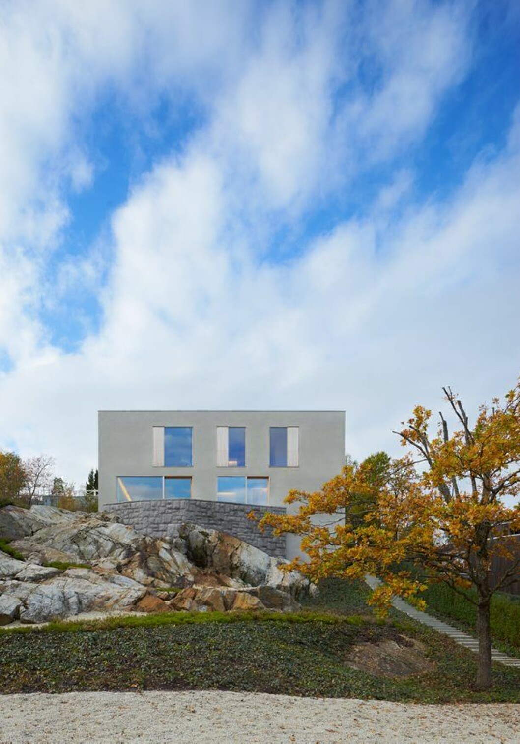 Naturstensmuren i granit övergår i en bergsslänt som i sin tur övergår i marktäckande murgröna. Johan Paju har varit ansvarig landskapsarkitekt. Villa Palmgren, John Pawson Limited
